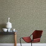 Modern red chair and table against a patterned green wall