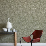 Modern red chair and table against a patterned green wall