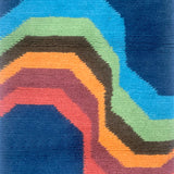 Handknotted carpet with a retro rainbow stripe on a blue field. 