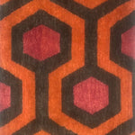 Handknotted rug sample in a retro hexagon design in red, brown and orange.