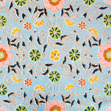 Detail of fabric in a playful floral print in pink, green and yellow on a light blue field.