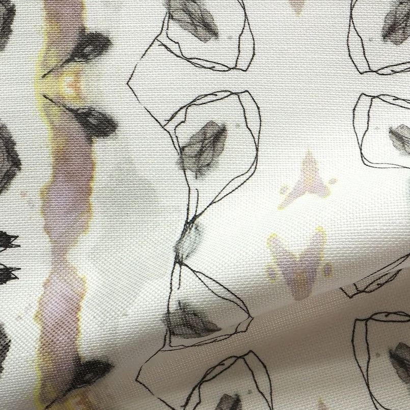 Detail of draped fabric yardage in an abstract ikat stripe print in shades of gray, pink and yellow on a white field.