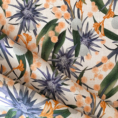 A piece of woven fabric with a large-scale purple, orange and hunter-green floral print on a cream background.