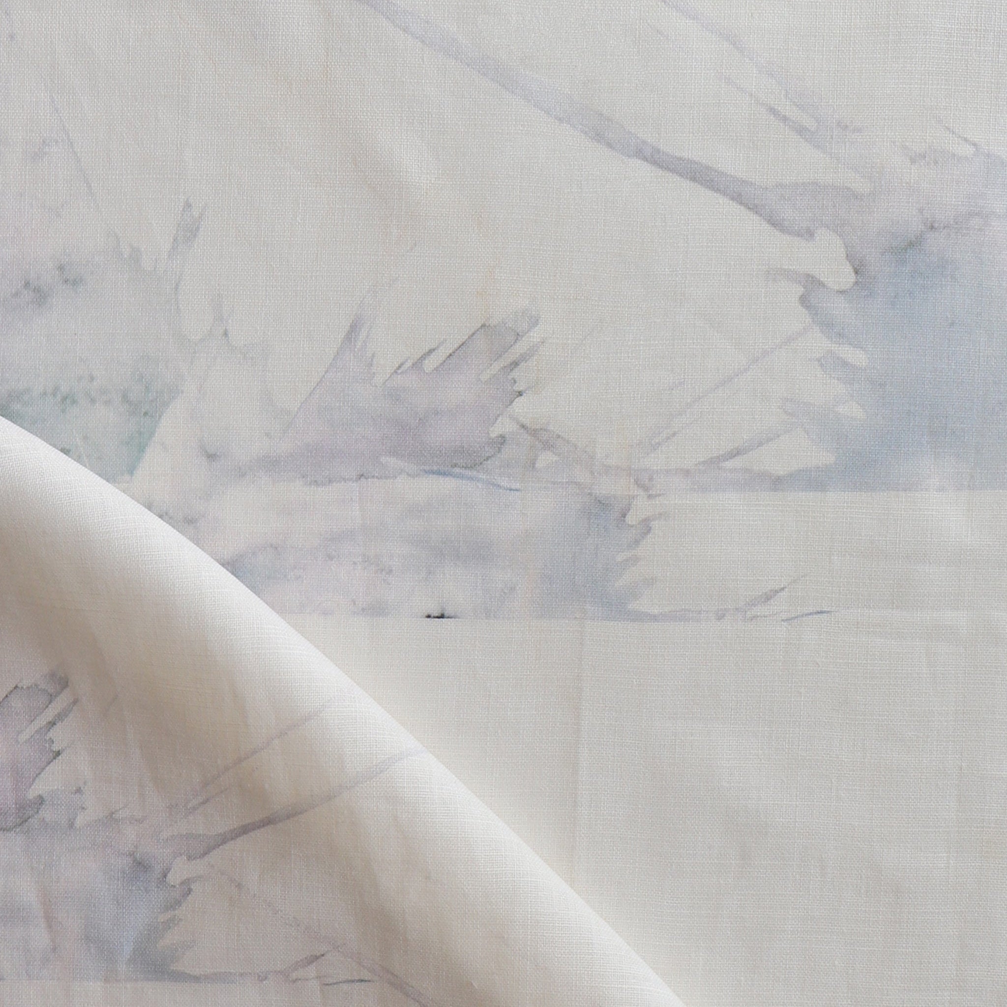 Draped fabric yardage in an abstract splatter print in pastel purple and gray on a cream field.