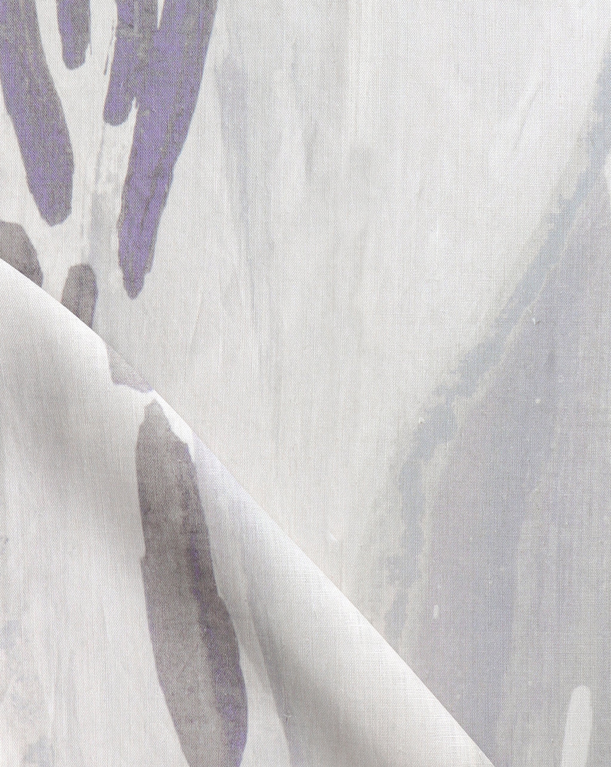 Draped fabric yardage in an abstract paint print in shades of purple and gray on a cream field.