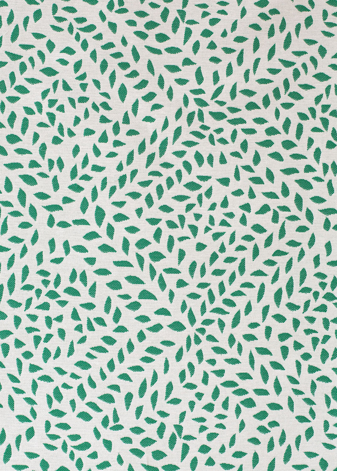 Detail of fabric in a botanical trellis print in green on a white field.