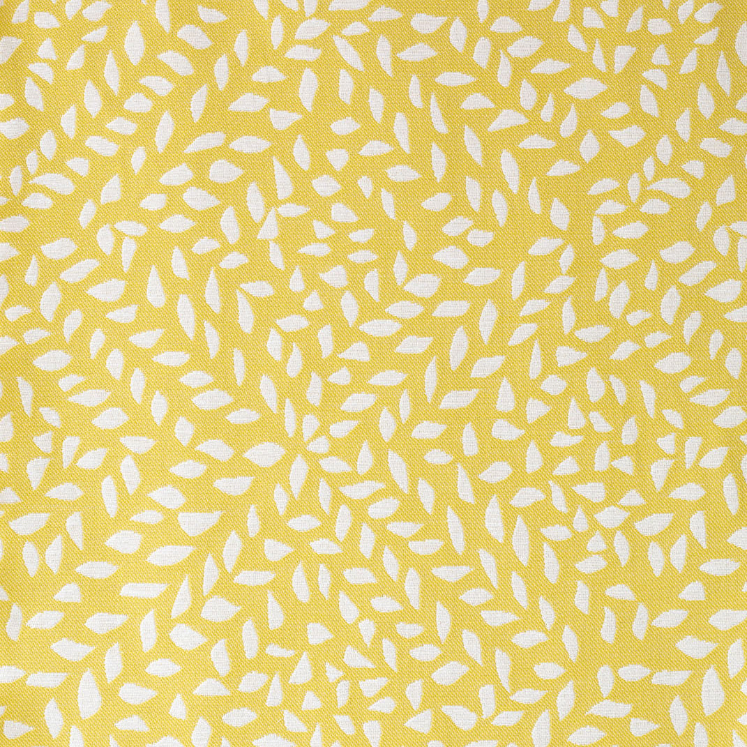 Detail of fabric in a botanical trellis print in white on a yellow field.