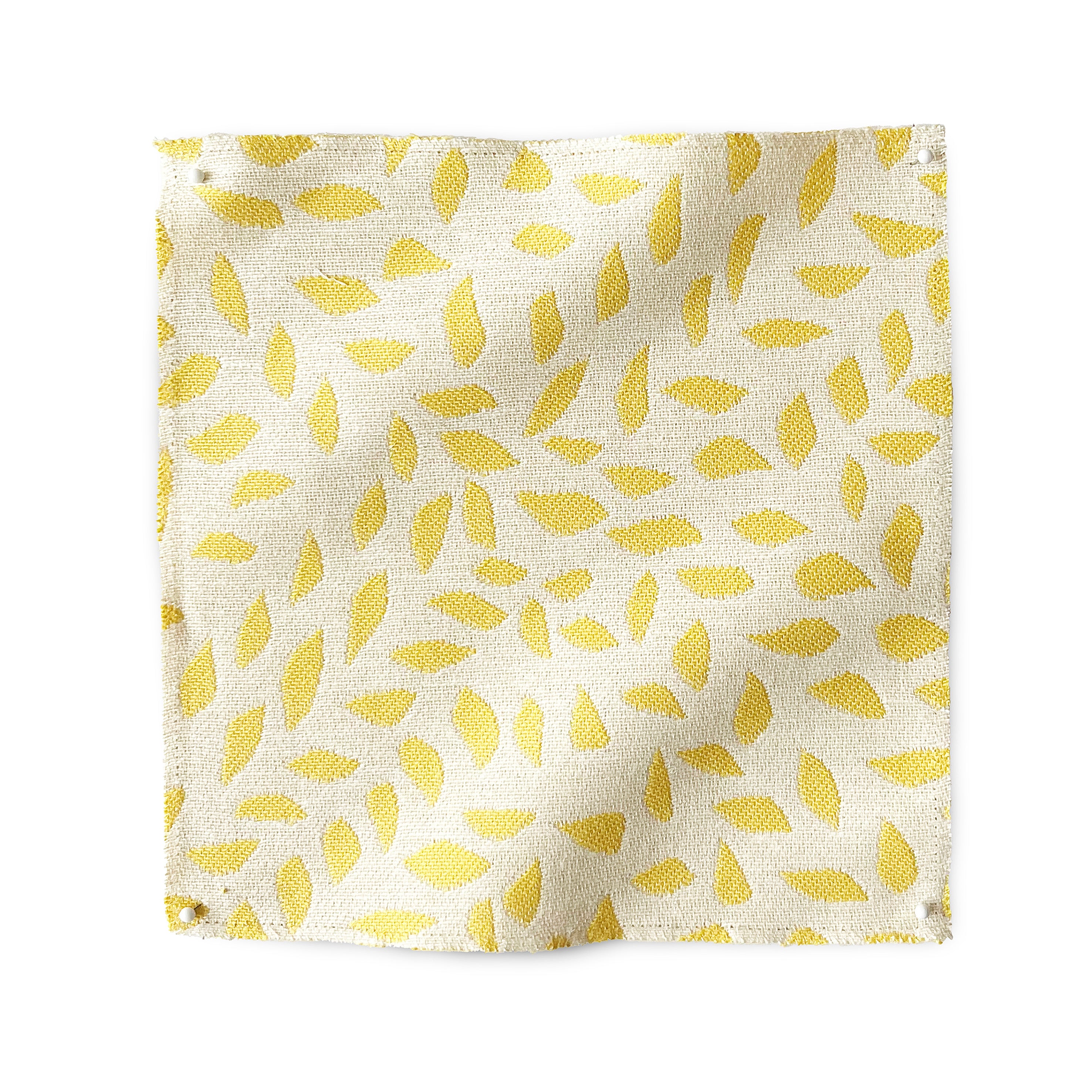 Square fabric swatch in a botanical trellis print in yellow on a white field.