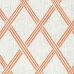 Detail of fabric in a diamond lattice print in orange on a white field.