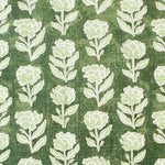 Detail of fabric in a classic floral print in pale green and white on a kelly green field.