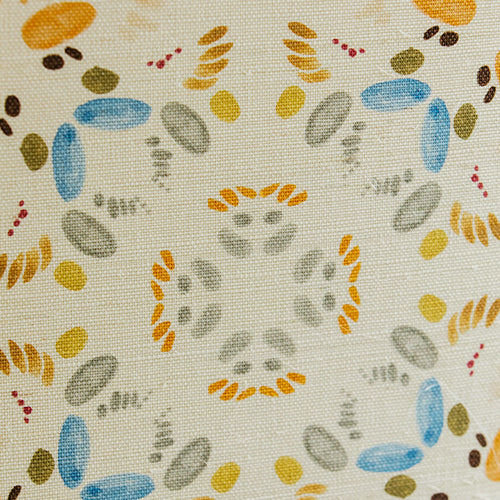 Detail of fabric in a painterly grid print in shades of blue and orange on a cream field.