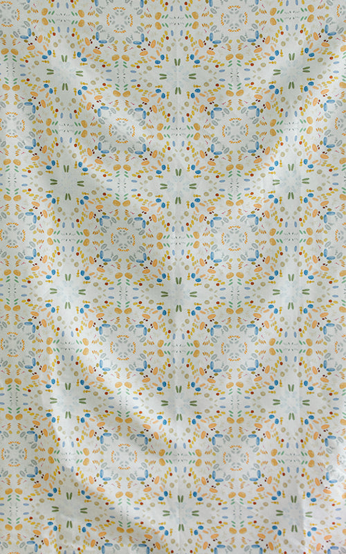 Detail of fabric in a painterly grid print in shades of blue and orange on a cream field.