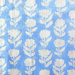 Detail of fabric in a classic floral silhouette print in cream on a light blue field