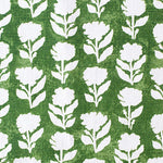 Detail of fabric in a classic floral silhouette print in cream on a dark green field