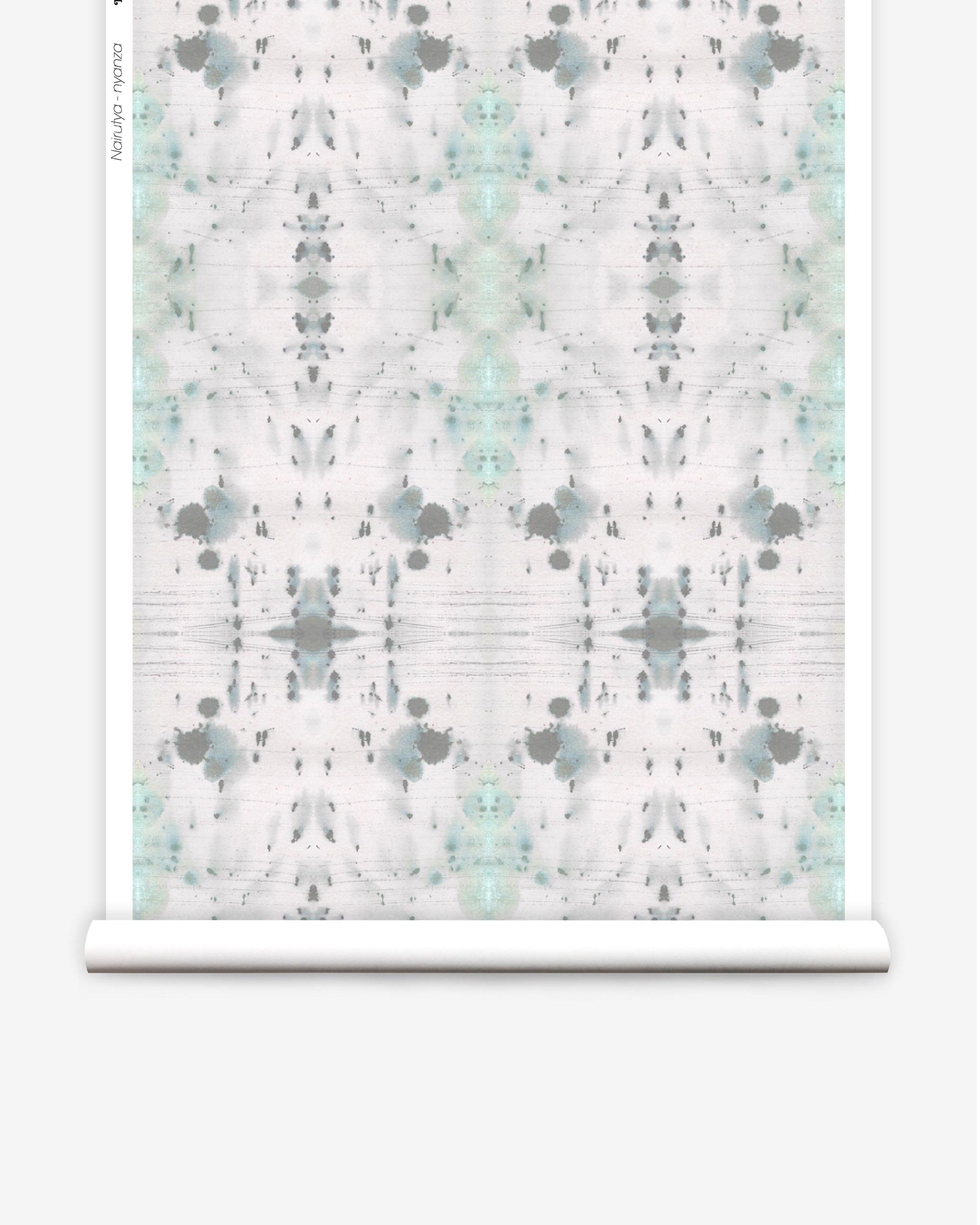 Partially unrolled wallpaper yardage in an abstract ink blot print in gray and green on a cream field.