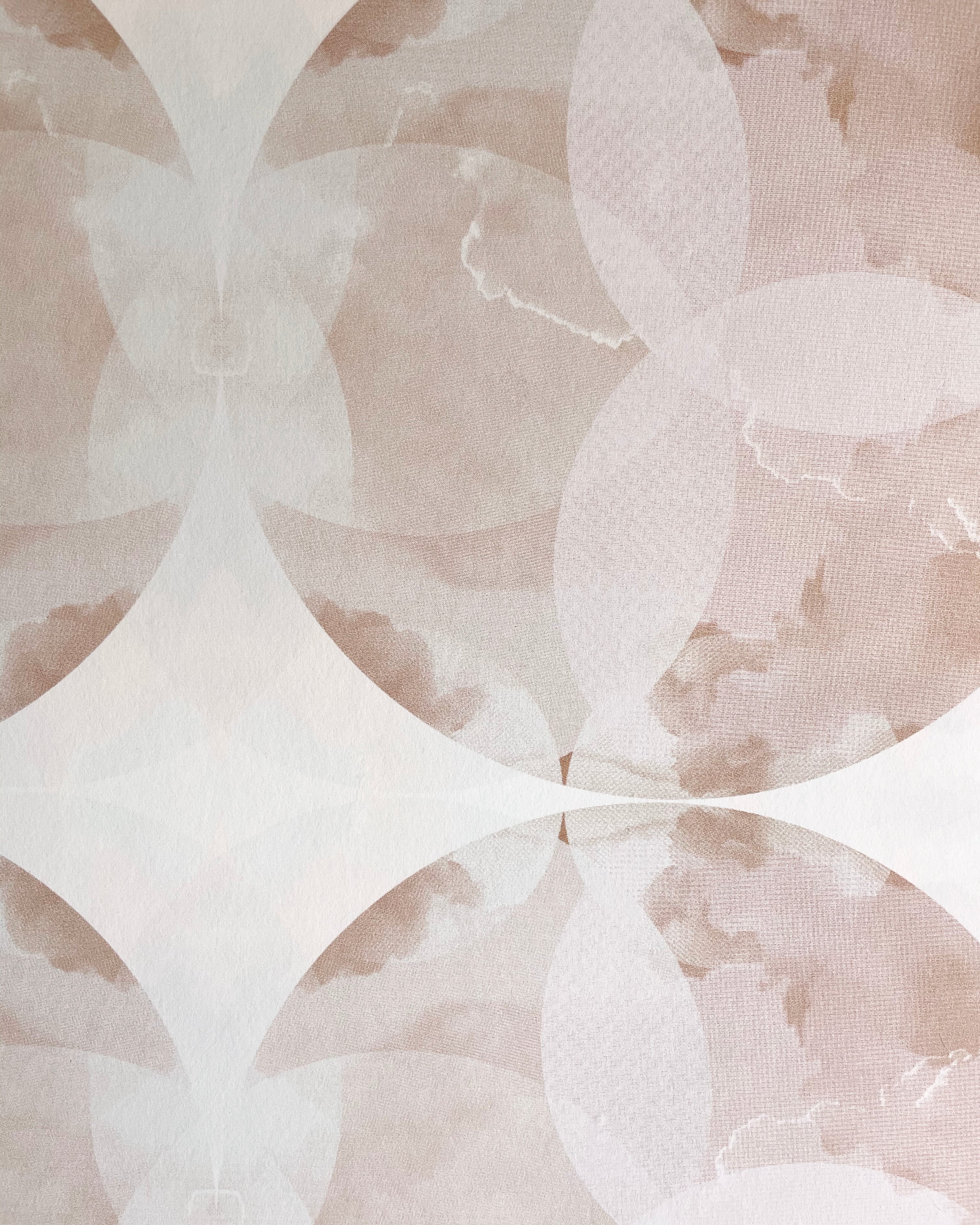 Close-up of wallpaper in a cloudy ink blot print in shades of brown and pink on a cream field.