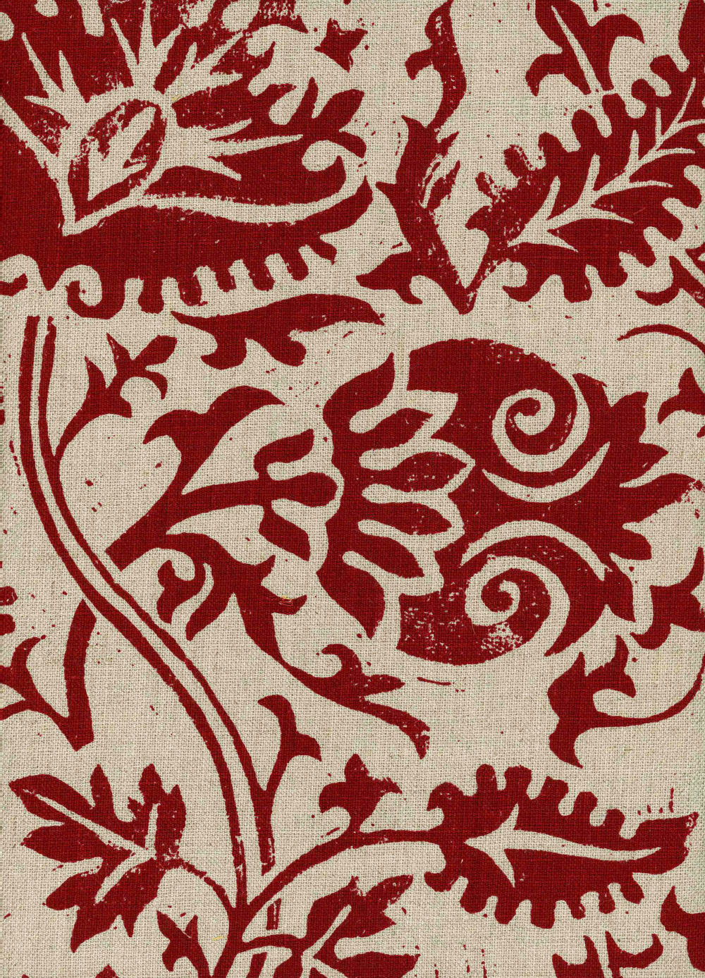 Detail of fabric in a floral damask print in red on a tan field.