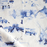 Draped fabric yardage in a playful painterly landscape print in navy on a cream field.