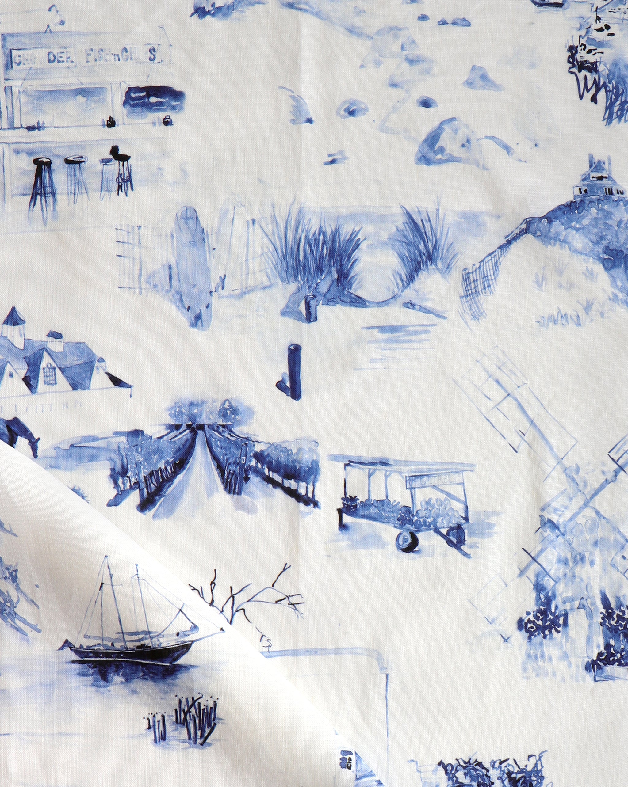 Draped fabric yardage in a playful painterly landscape print in navy on a cream field.