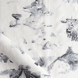 Draped fabric yardage in a playful painterly landscape print in gray on a cream field.