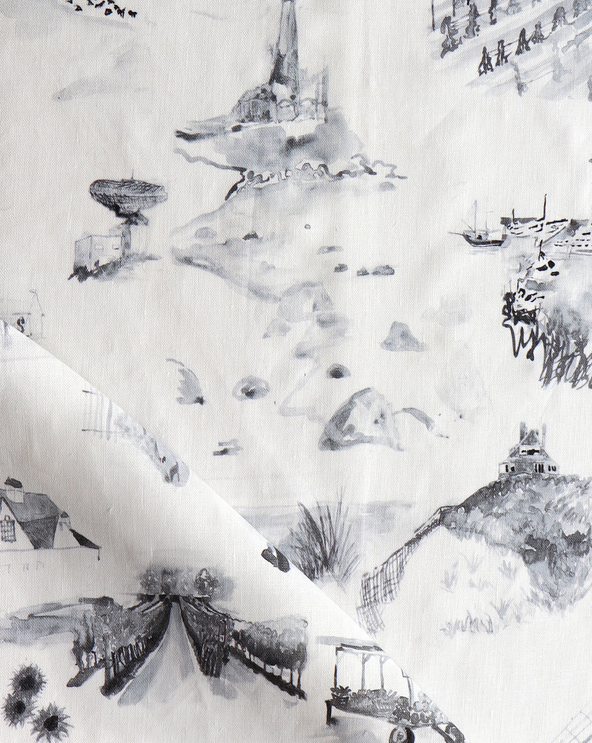 Draped fabric yardage in a playful painterly landscape print in gray on a cream field.