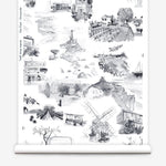 Partially unrolled wallpaper yardage in a playful illustrated city print in gray, black and white.