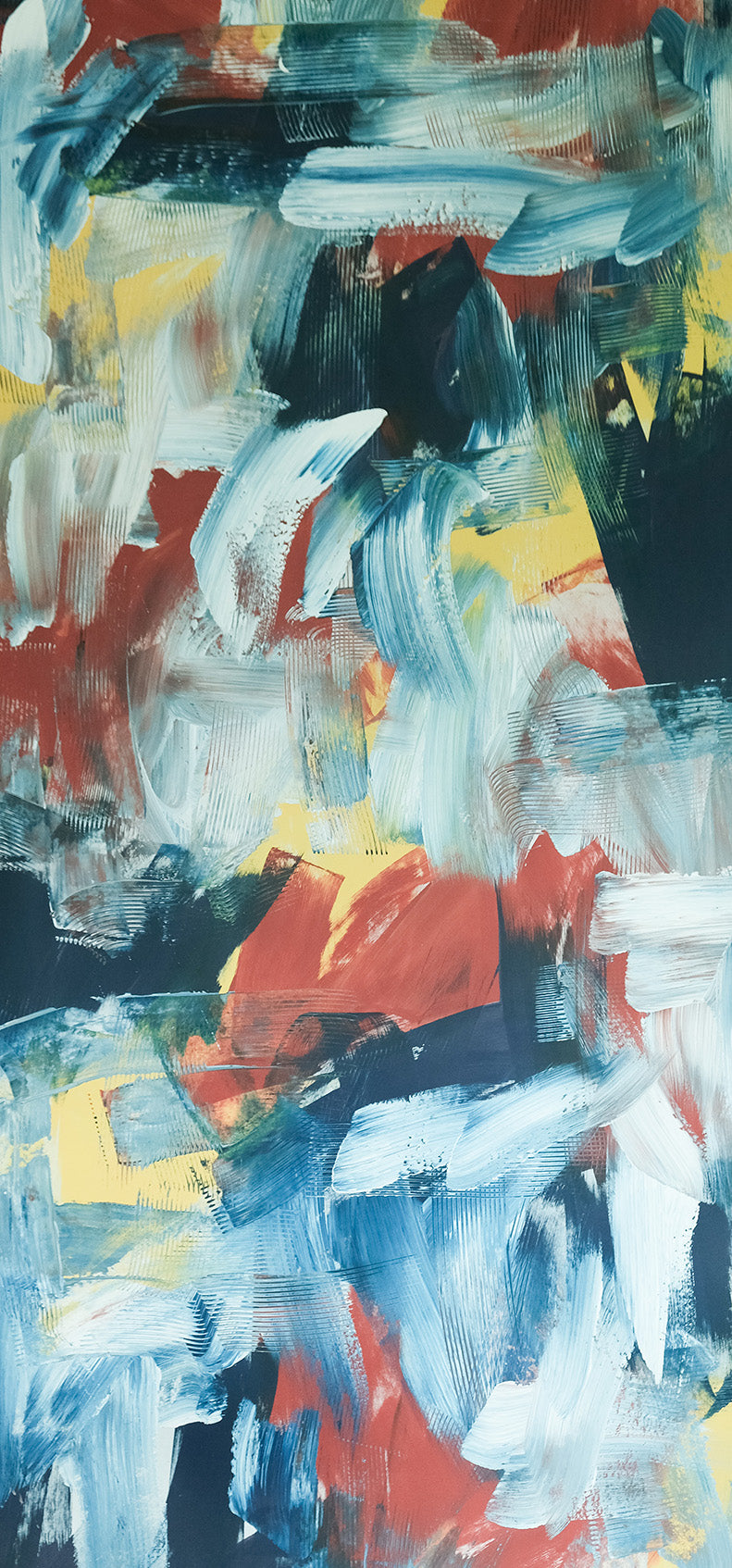 Detail of wallpaper in an abstract paint print in shades of red, blue, yellow and white.