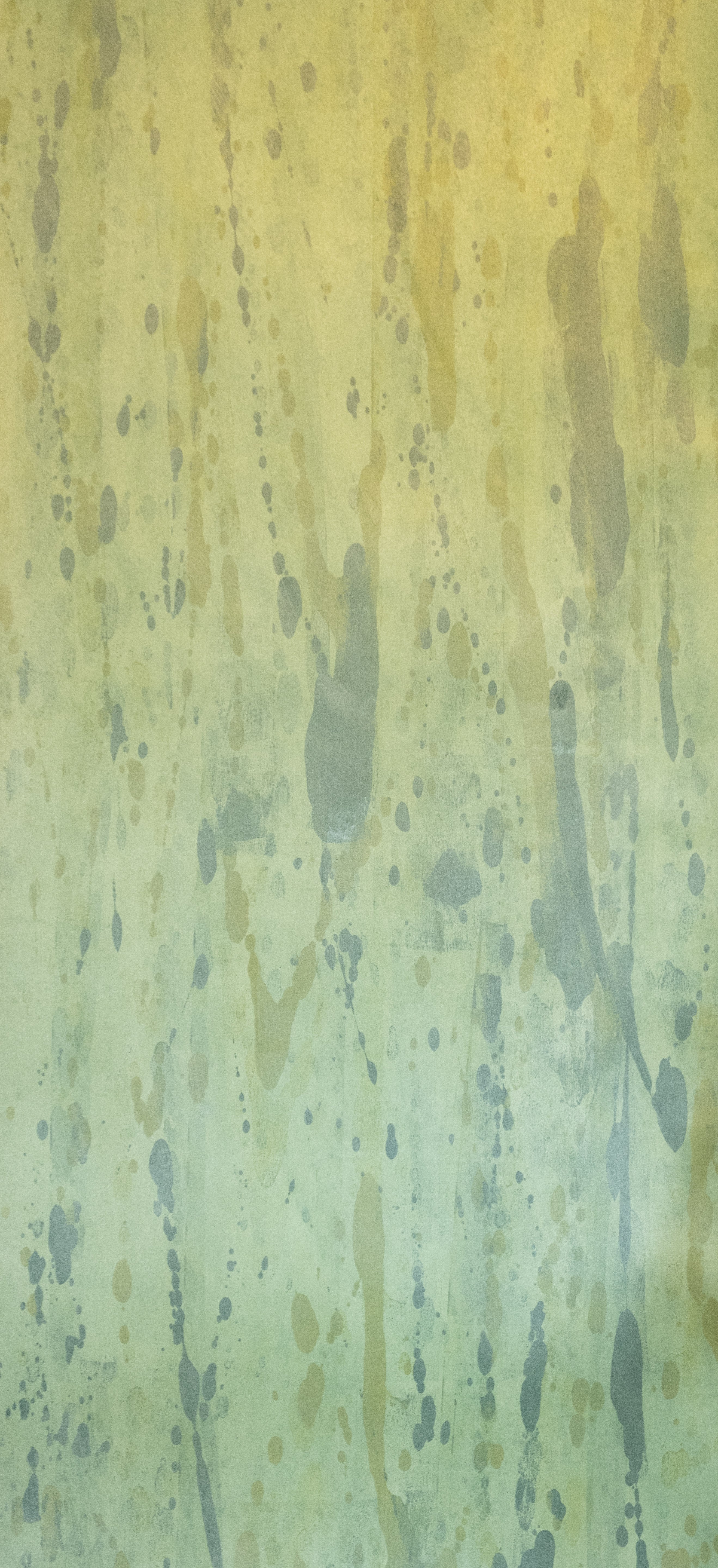 Detail of wallpaper in a textural paint splatter print in shades of green and blue.