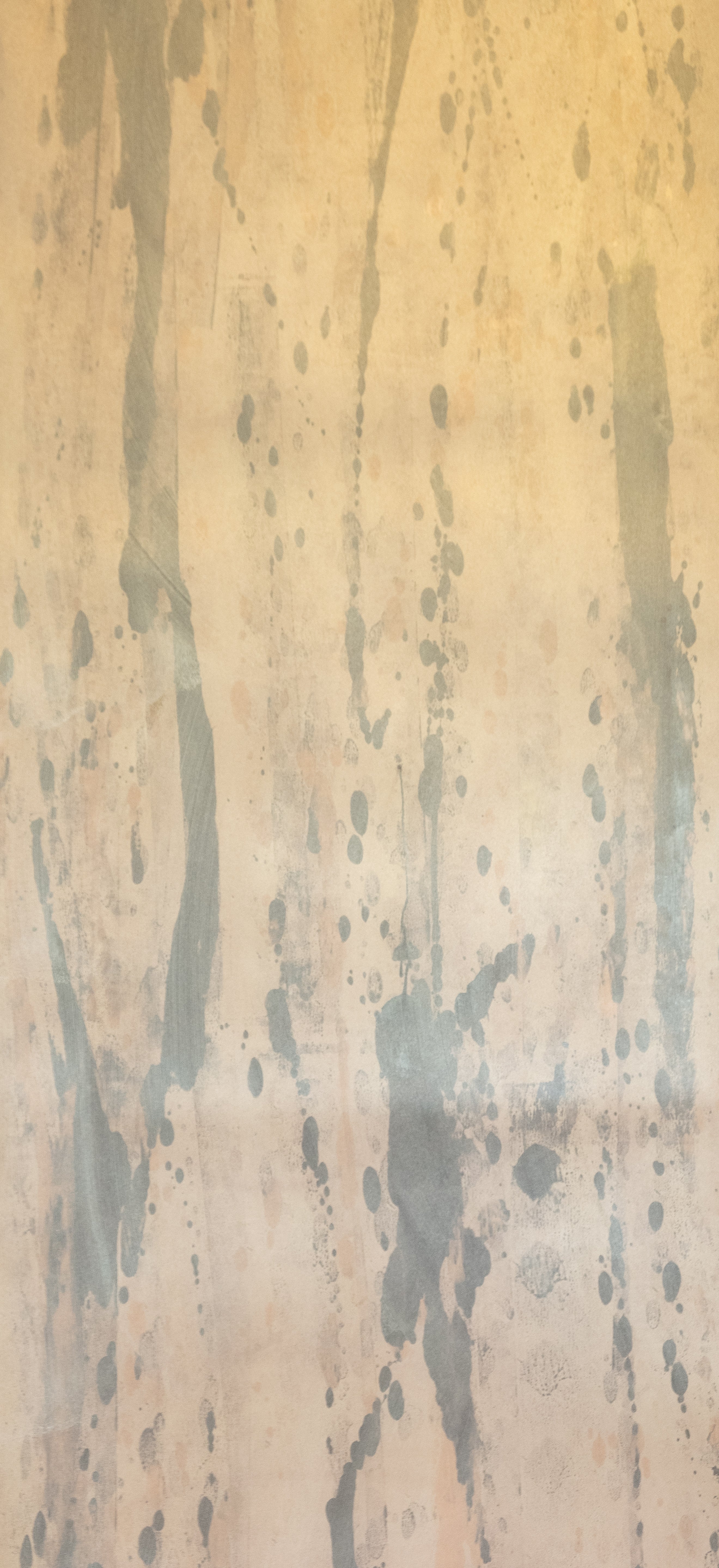 Detail of wallpaper in a textural paint splatter print in shades of gray and tan.