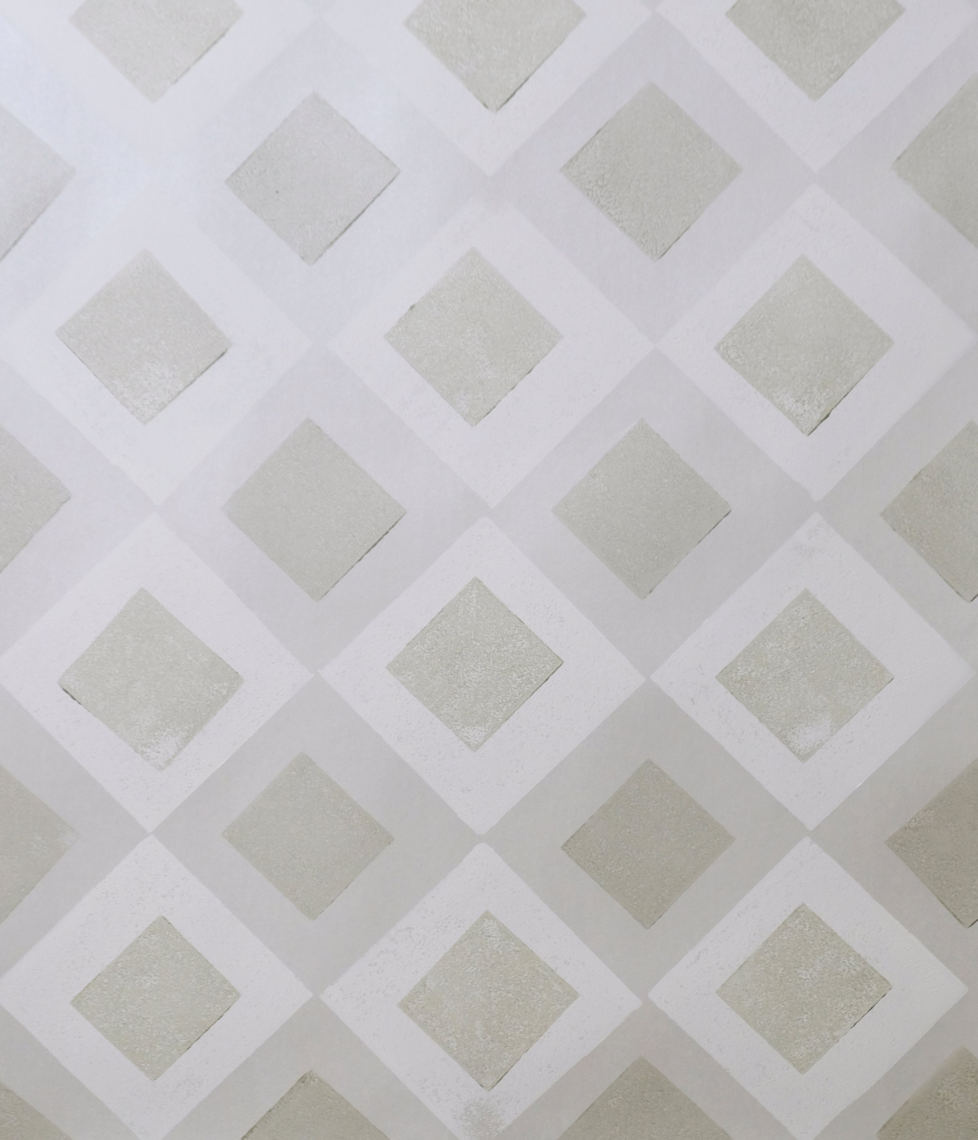 Detail of wallpaper in a diamond lattice print in shades of cream and grey.