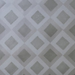 Detail of wallpaper in a diamond lattice print in shades of gray.