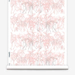 Partially unrolled wallpaper yardage in a painterly palm tree stripe print in pink, gray and white.