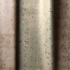 Three rolls of wallpaper in a row. Each has a delicate splatter print and a metallic finish in copper, silver or bronze.