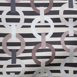 Draped fabric in a playful paper chain stripe print in shades of cream, brown and black.