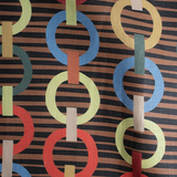 Draped fabric in a playful paper chain stripe print in a rainbow of shades on a black field.