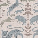 Detail of fabric in a playful animal and botanical print in brown and blue on a cream field.