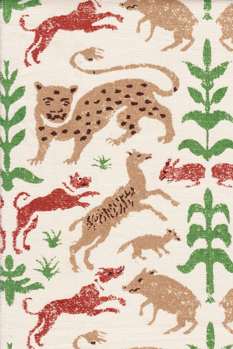 Detail of fabric in a playful animal and botanical print in brown, red and green on a white field.