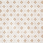 Detail of fabric in a dainty floral lattice print in tan on a cream field.