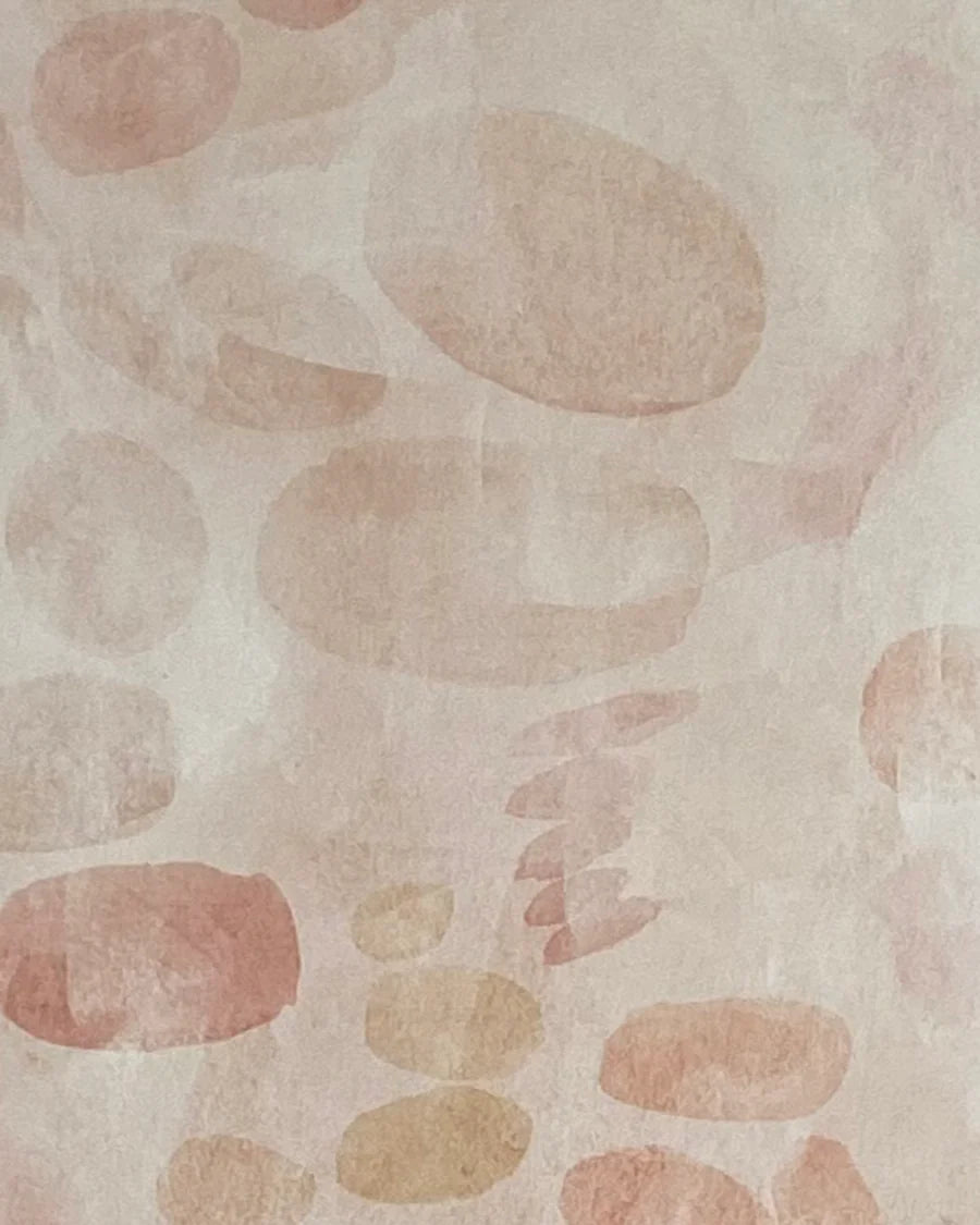 Detail of wallpaper in a playful paint blotch print in shades of light pink on a cream field.