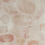 Detail of wallpaper in a playful paint blotch print in shades of light pink on a cream field.