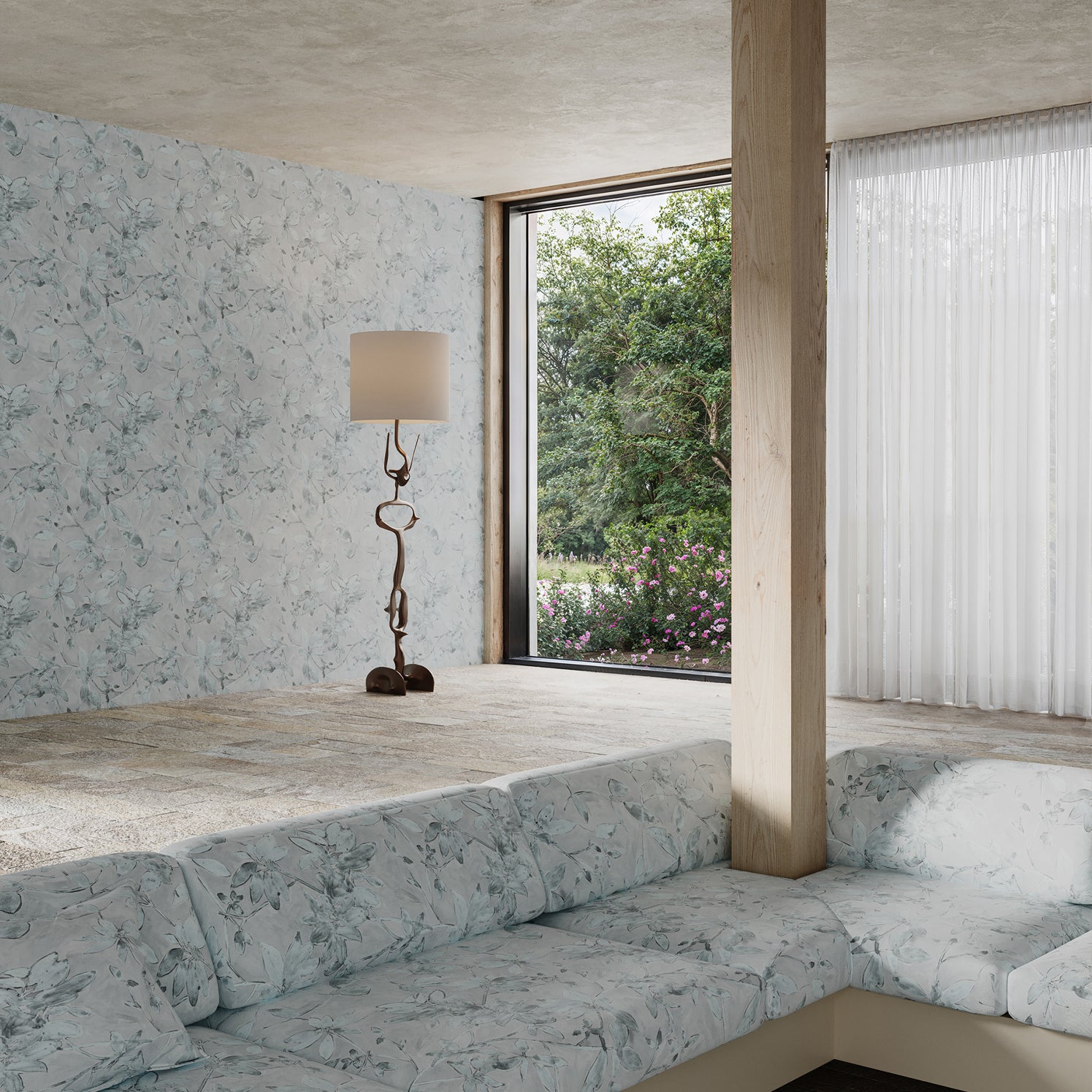 Modern living room with a large window, gray sofa, and decorative lamp with delicate floral wallpaper and upholstery.