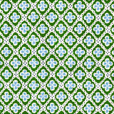 Detail of fabric in a floral lattice print in blue and green on a white field.