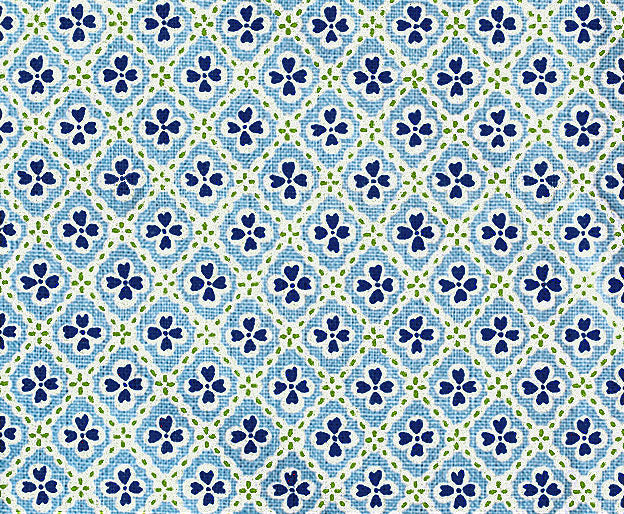 Detail of fabric in a floral lattice print in shades of blue, navy and light green.