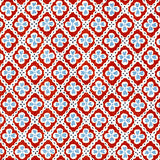 Detail of fabric in a floral lattice print in blue and red on a white field.