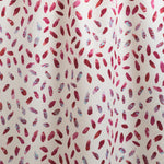 Draped fabric yardage in a playful paint blotch print in shades of pink and turquoise on a white field.