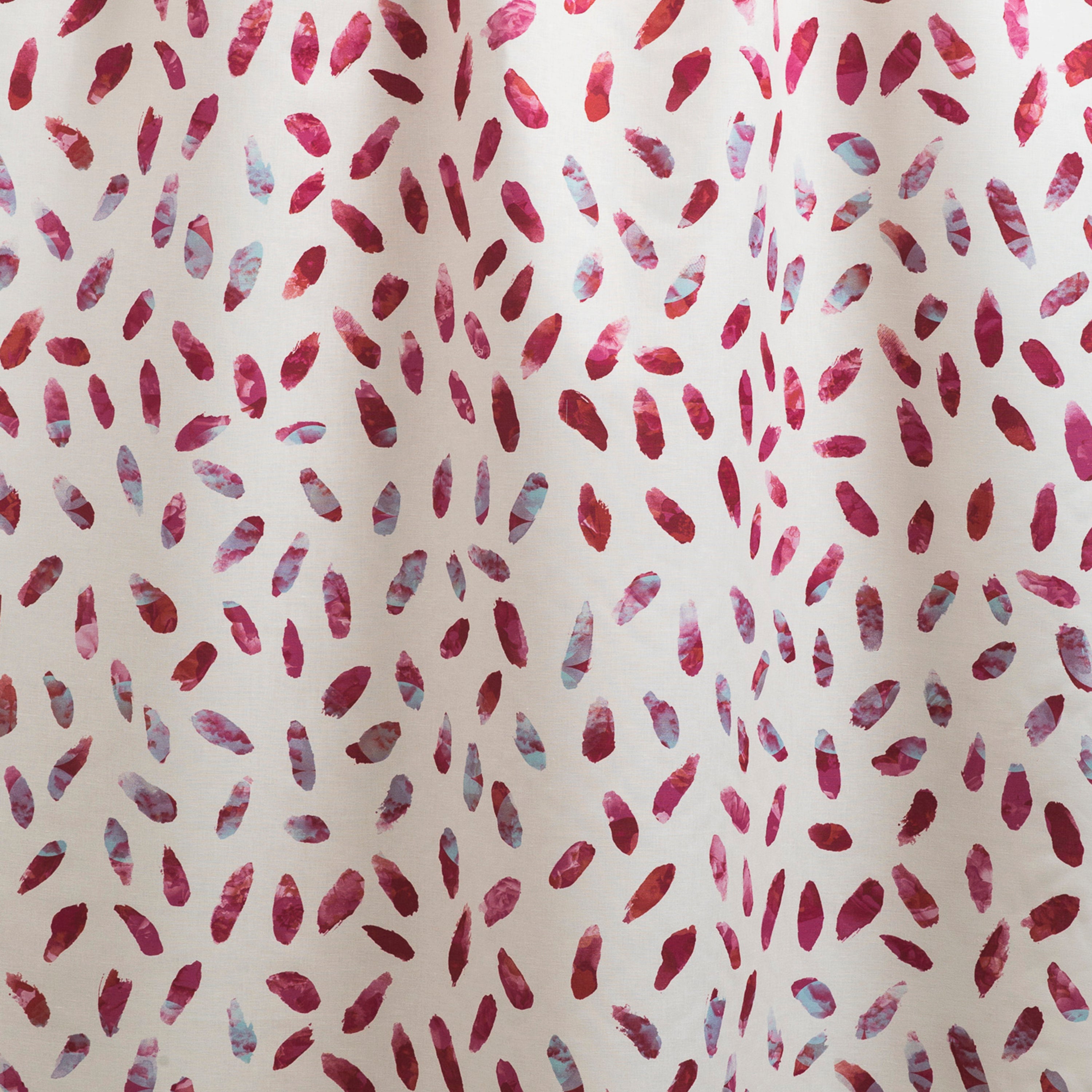 Draped fabric yardage in a playful paint blotch print in shades of pink and turquoise on a white field.