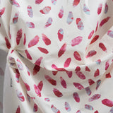 Crumpled fabric yardage in a playful paint blotch print in shades of pink and turquoise on a white field.