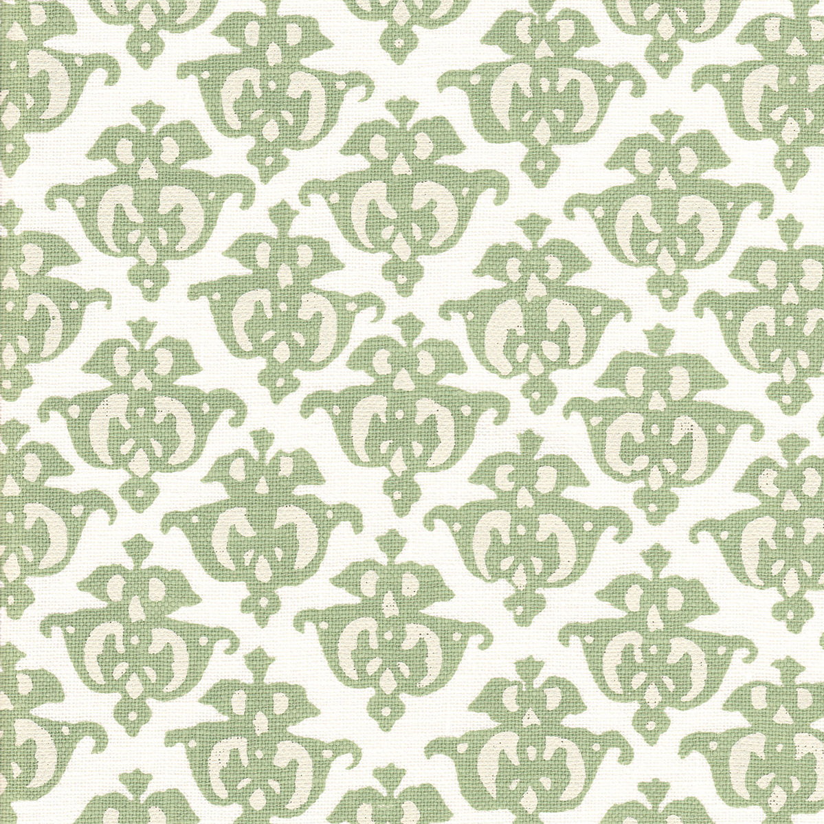 Detail of fabric in a repeating damask print in green and cream on a white field.