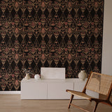 An armchair and credenza stand in front of a wall papered in a floral and diamond lattice print in pink, tan and black.