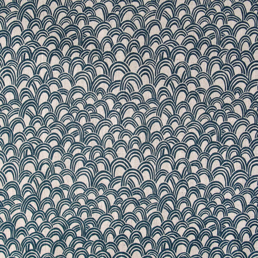 Detail of fabric in a playful repeating hoop pattern in navy on a tan field.
